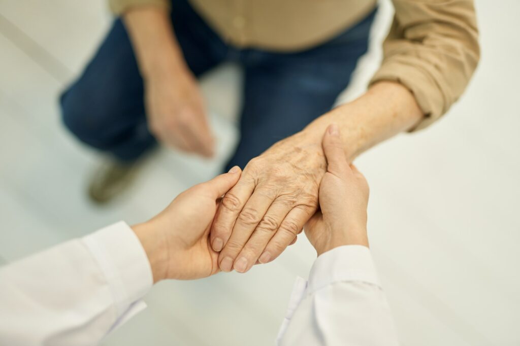 Geriatric specialist examining age changes of elderly patient hands